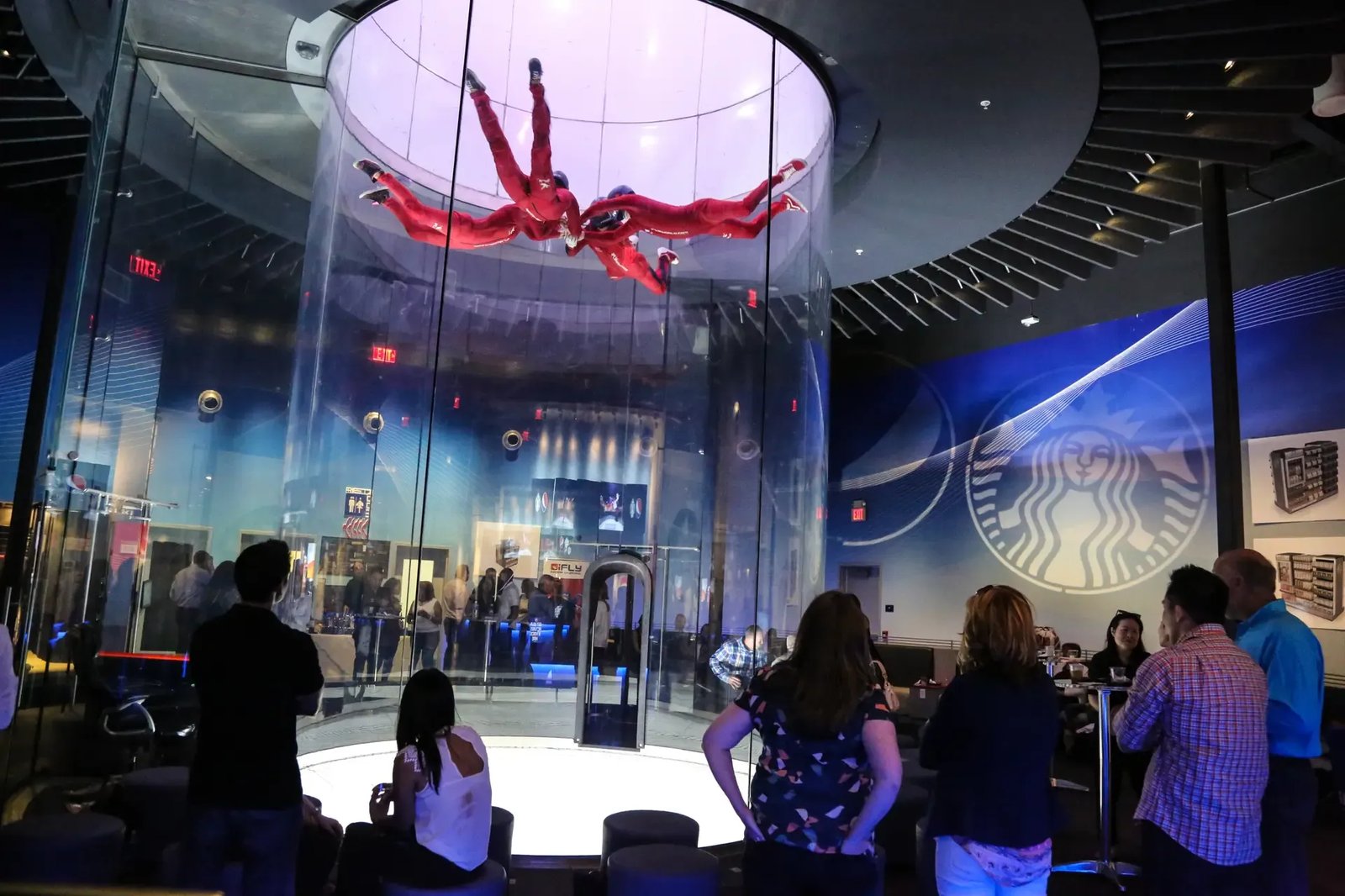 Group of people flying in the iFLY Indoor Skydiving vertical wind tunnel, Davie, Florida