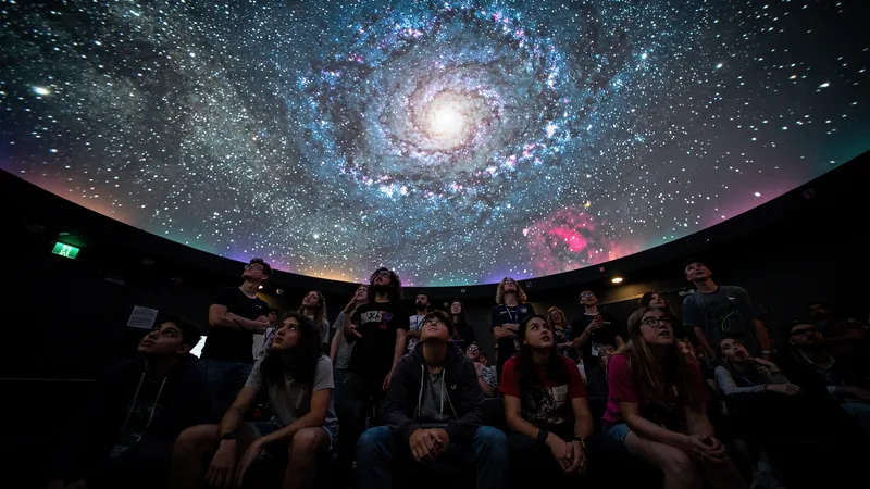 Children watching an astronomy presentation inside a planetarium