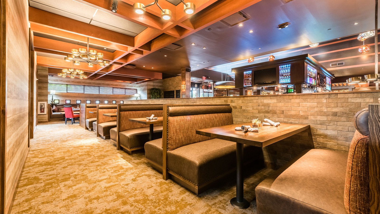 Brimstone Woodfire Grill upscale interior — warm booth seating and polished dining room at Shops at Pembroke Gardens