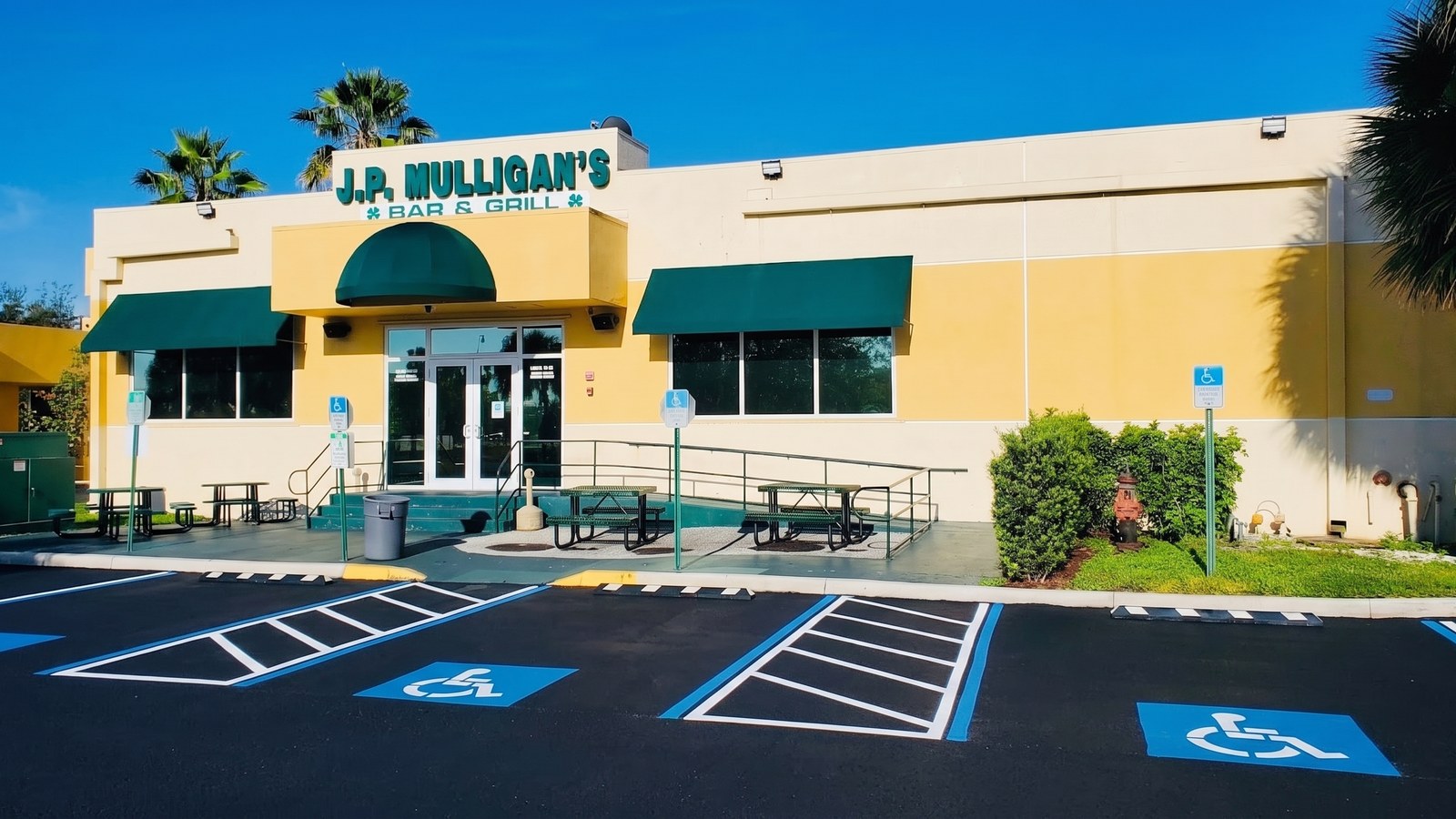 JP Mulligans Restaurant & Pub exterior at 12415 Taft Street Pembroke Pines — cream-colored storefront with J.P. MULLIGAN'S BAR & GRILL signage, green awnings, and entrance